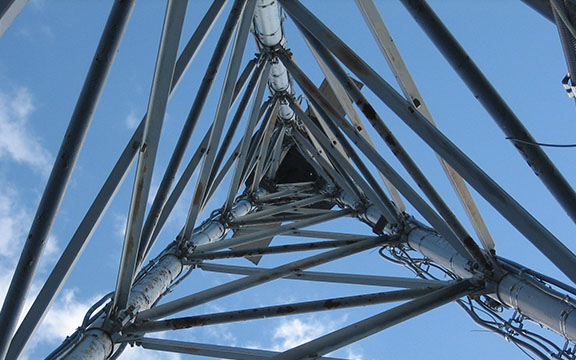 Looking up inside triangular steel transmission tower