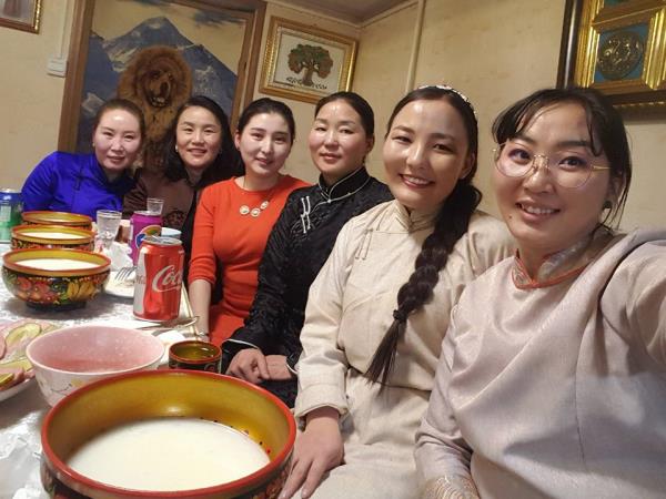 Six women smiling around table with bowls
